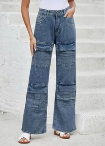 Detail of high-waisted wide-leg cargo jeans with washed blue texture and large side pockets
