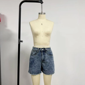 Détail d'un short en jean taille haute délavé vintage avec ourlets effilochés et boutons