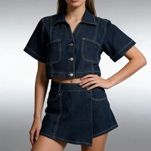 Dettaglio di un completo due pezzi in denim blu scuro con cuciture a contrasto