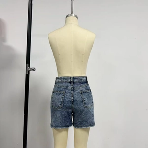 Détail du short en jean bleu délavé à taille haute avec bords effilochés au dos