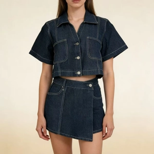 Vista frontale di un set in denim blu scuro con camicia corta e gonna asimmetrica coordinata