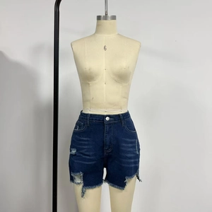 Detail of high-waisted dark blue distressed denim shorts with frayed hems and ripped texture