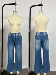 Détail d'un jean bleu délavé avec taille élastique et cordons de serrage blancs ajustables