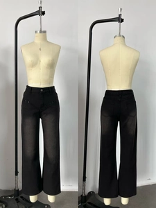 Detail of high waisted black washed denim jeans with straight leg fit and faded finish