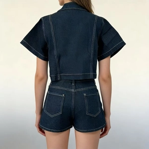 Vista posteriore del set in denim blu scuro con pantaloncini a vita alta e cuciture bianche