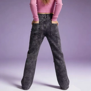 Back view of high-waisted acid wash cargo jeans with large pockets on studio background