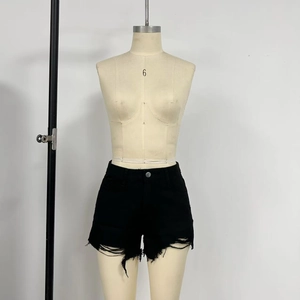 Detail of high waist black denim shorts featuring frayed edges and distressed raw hem