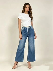 Détail de la taille haute à cordon sur le pantalon en jean bleu moyen à jambe large