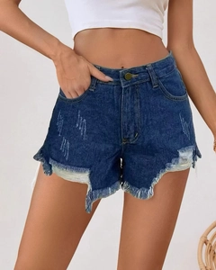 Detail view of high-waisted distressed denim shorts with raw hem and vintage wash finish