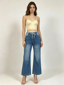 Détail du pantalon large en jean bleu à taille haute avec cordon de serrage blanc