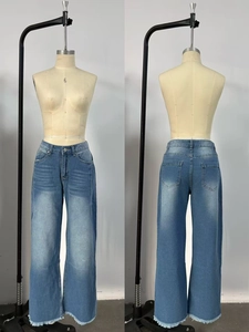 Détails d'un jean large bleu clair avec moustaches rétro et ourlet effiloché usé