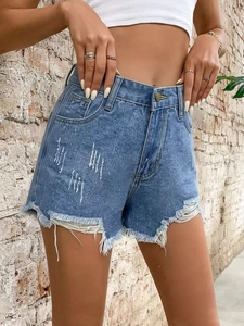 Detail showing distressed denim shorts with raw fringe edges and unique pattern print