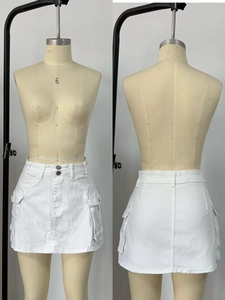 Detailed view of white denim utility mini skirt featuring large flap pockets and double buttons