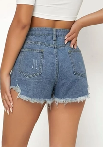 Detail view of high-waisted blue denim shorts with monogram pattern and frayed raw hem