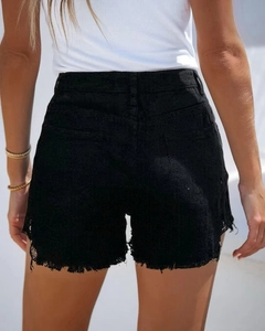 Detail view of high waist black denim shorts with frayed hems and embossed texture