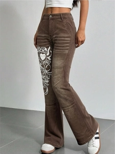 Détail d'un jean évasé marron Y2K avec motif cœur blanc et texture denim délavé