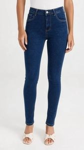 Detail of high waisted skinny jeans in dark blue with natural whiskering effect