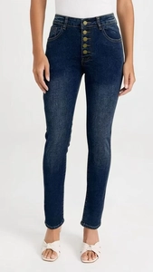 Detail of high waisted skinny jeans with five golden buttons and textured denim fabric
