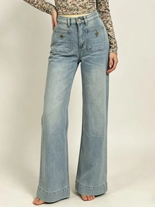 Dettaglio jeans azzurri a vita alta con gamba larga e tasche quadrate con bottoni