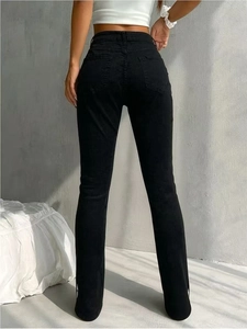 Detail view of high waist skinny black jeans featuring a subtle side slit hem for women