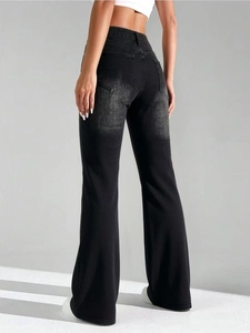 Détail du jean évasé noir à taille haute avec poches arrière et texture denim délavé vintage