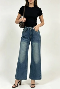 Dettaglio dei jeans a vita alta con lavaggio bianco e stampa a fiocco di tendenza