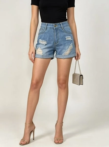 Détail d'un short en jean taille haute bleu clair avec effet usé et ourlets retroussés