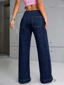 Dettaglio delle cuciture bianche a contrasto e tasche posteriori sui jeans blu scuro