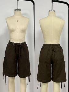 Dettaglio di pantaloncini cargo marrone scuro con coulisse in vita e grandi tasche laterali