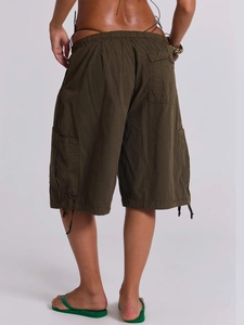 Dettaglio dei pantaloncini cargo verde oliva con coulisse sull'orlo e grandi tasche a patta