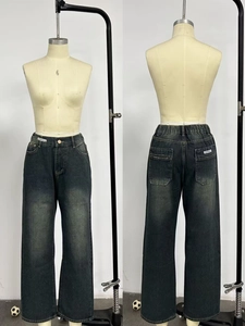 Detail view of high-waist loose denim jeans showing front pockets and vintage wash effect