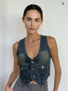 Détail du gilet en jean bleu vintage avec col en V, boutons en métal et poches cargo