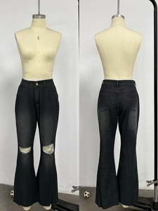 Dettaglio degli strappi sulle ginocchia e del taglio a zampa dei jeans neri