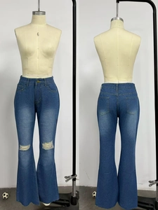 Dettaglio jeans a vita alta con strappi alle ginocchia e orlo svasato a taglio vivo sul manichino
