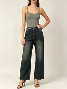 Close-up of high-waisted dark grey wide-leg denim jeans with vintage wash and cat whiskers