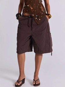 Dettaglio dei pantaloncini cargo marrone scuro con coulisse in vita e grandi tasche laterali