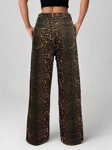 Detail view of high-waist leopard print wide-leg jeans with back pockets on a model