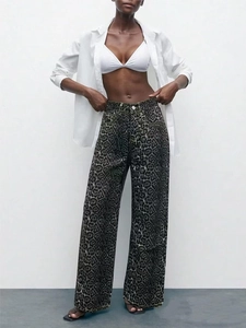 Detail view of high-waisted wide-leg denim pants featuring a trendy leopard print pattern
