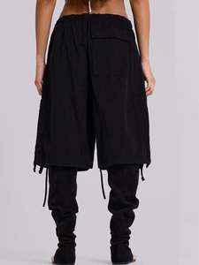Dettaglio dei pantaloncini cargo neri con elastico in vita, tasca posteriore e coulisse