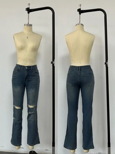 Detailansicht der blauen High-Waist-Jeans mit Rissen, ausgestelltem Bein und Gesäßtaschen
