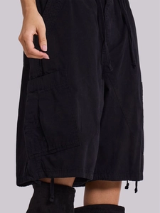 Dettaglio di pantaloncini cargo neri in denim con grandi tasche e coulisse in vita