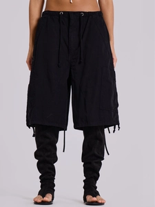 Dettaglio dei pantaloncini cargo neri con grandi tasche e design con coulisse lunga