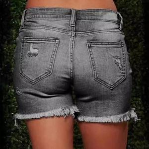 Détail du short en jean avec ourlets effilochés, déchirures et poches arrière en gris anthracite