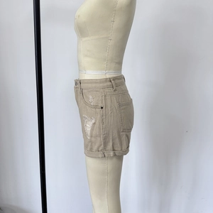 Vue latérale d'un short en jean kaki avec détails déchirés sur un mannequin de couture