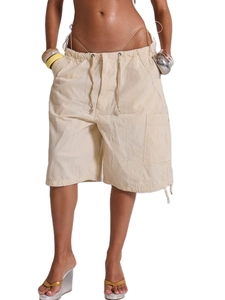 Dettaglio degli shorts cargo beige con coulisse in vita e grandi tasche laterali utility