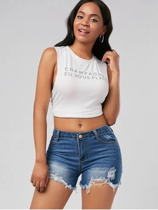 Detail of distressed denim shorts with frayed hems and white graphic tank top