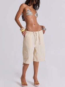 Dettaglio dei pantaloncini cargo in denim beige con coulisse e grandi tasche laterali