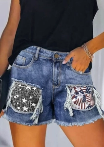 Detailed close-up of distressed denim shorts with star pattern pockets and frayed edges