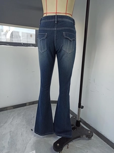 Detail view of high waist flared jeans with contrast white stitching and flap pockets