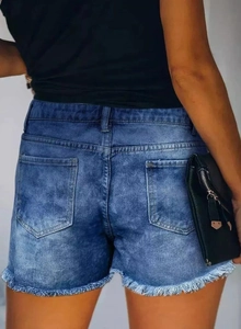 Detailed back view of distressed dark blue denim shorts with raw hem and retro wash texture